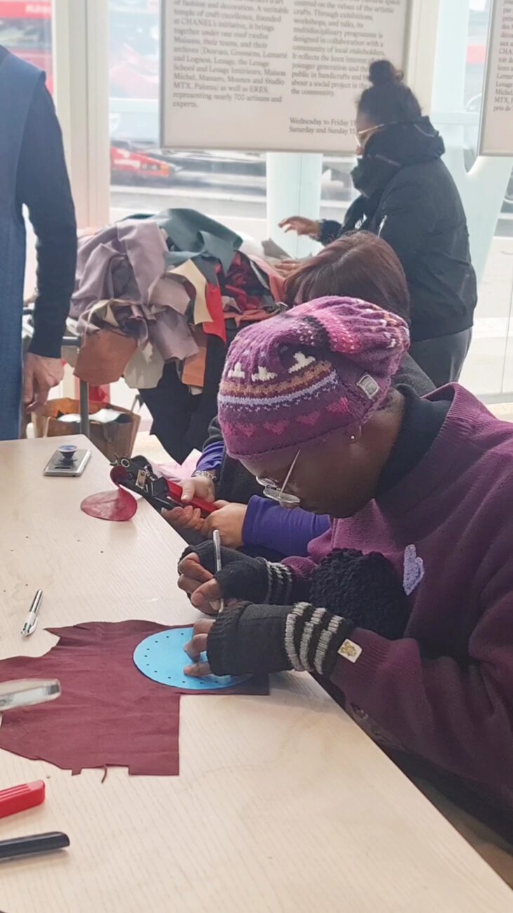 A DLOKI artisan embroidering a portrait by hand in the atelier